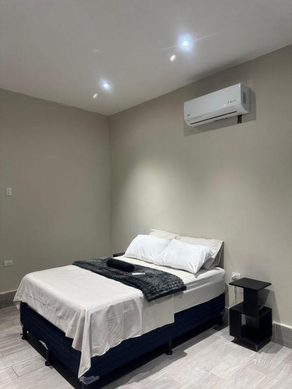 a bedroom with a bed and a air conditioner on the wall at Casa KM222 in Esquipulas