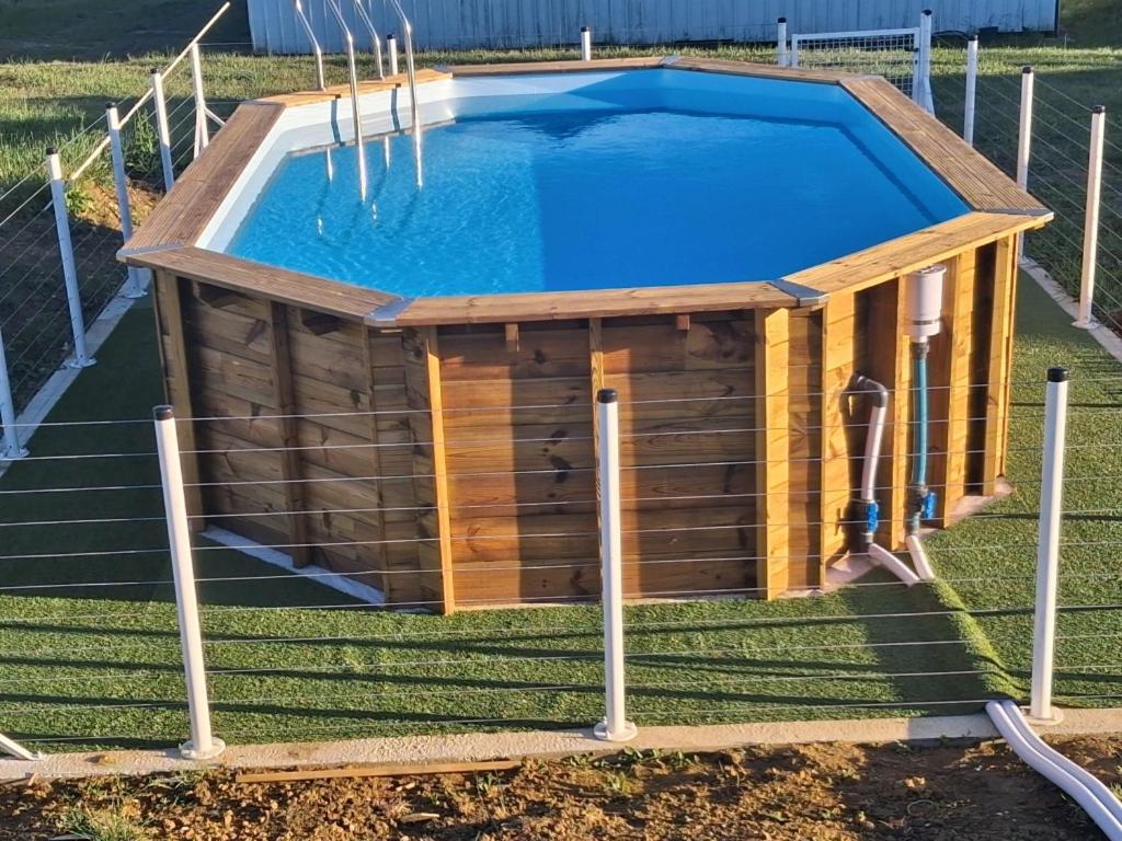 a pool in a backyard with a wooden house at maison de campagne rénovée avec piscine in Duras