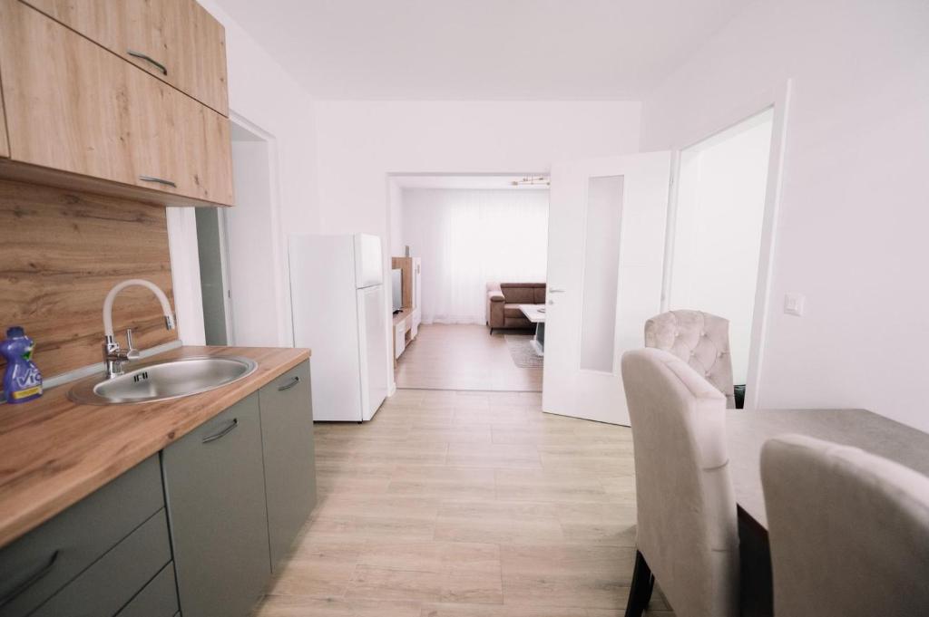 a kitchen with a sink and a table and a refrigerator at KDolićiM in Livno