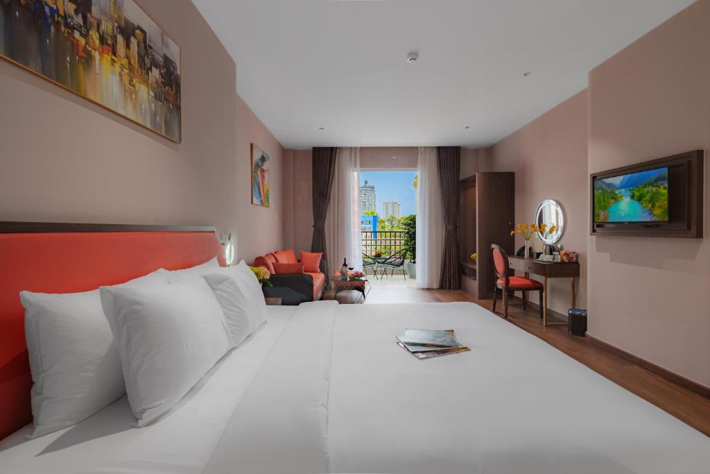 a bedroom with a large white bed and a desk at Sono Sallute Luxury Hotel in Ho Chi Minh City