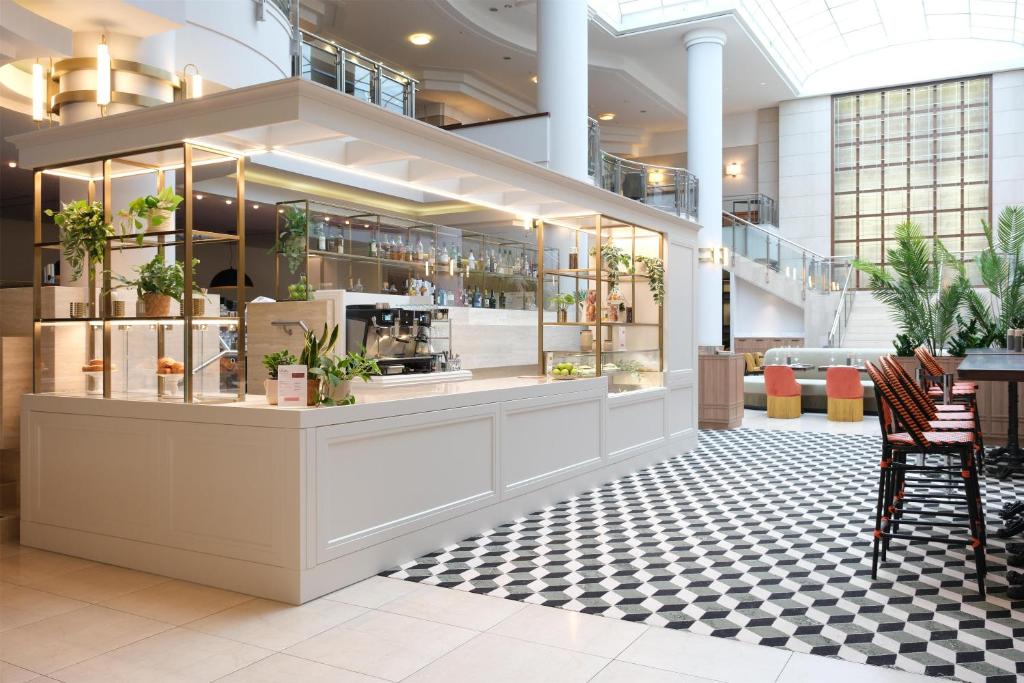 a lobby with a counter with plants in it at Hilton Berlin in Berlin