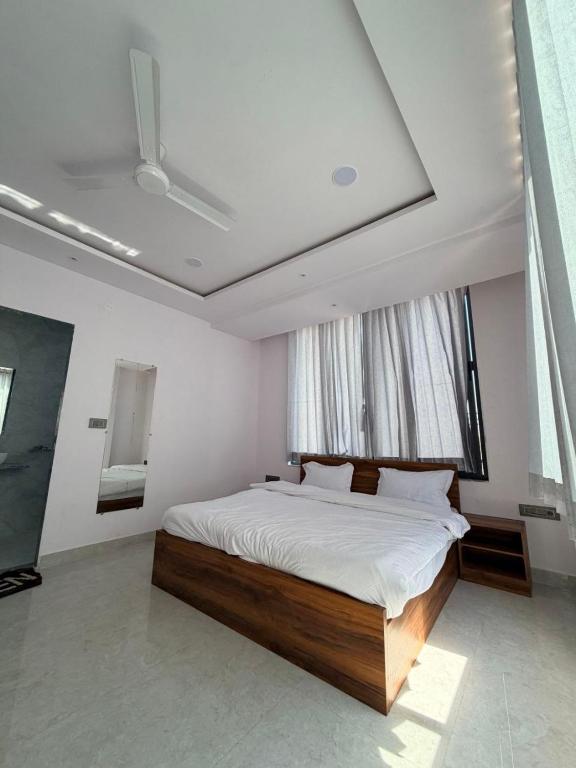 a bedroom with a large bed with white sheets at Karma Palace Hotel in Pushkar