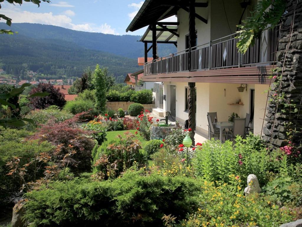 una casa con un jardín de flores delante de ella en Ferienwohnungen Gästehaus Schreiner, en Arrach