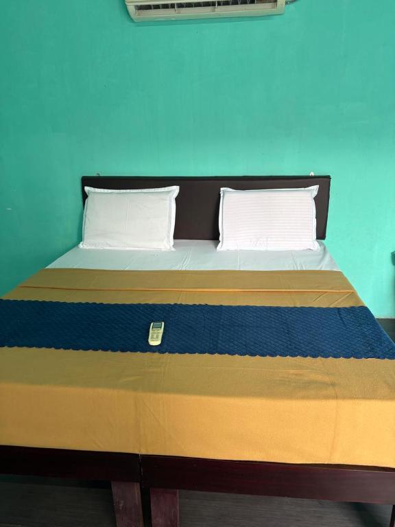 a bed with two pillows on it in a room at Bhudda Lodge in Tirupati