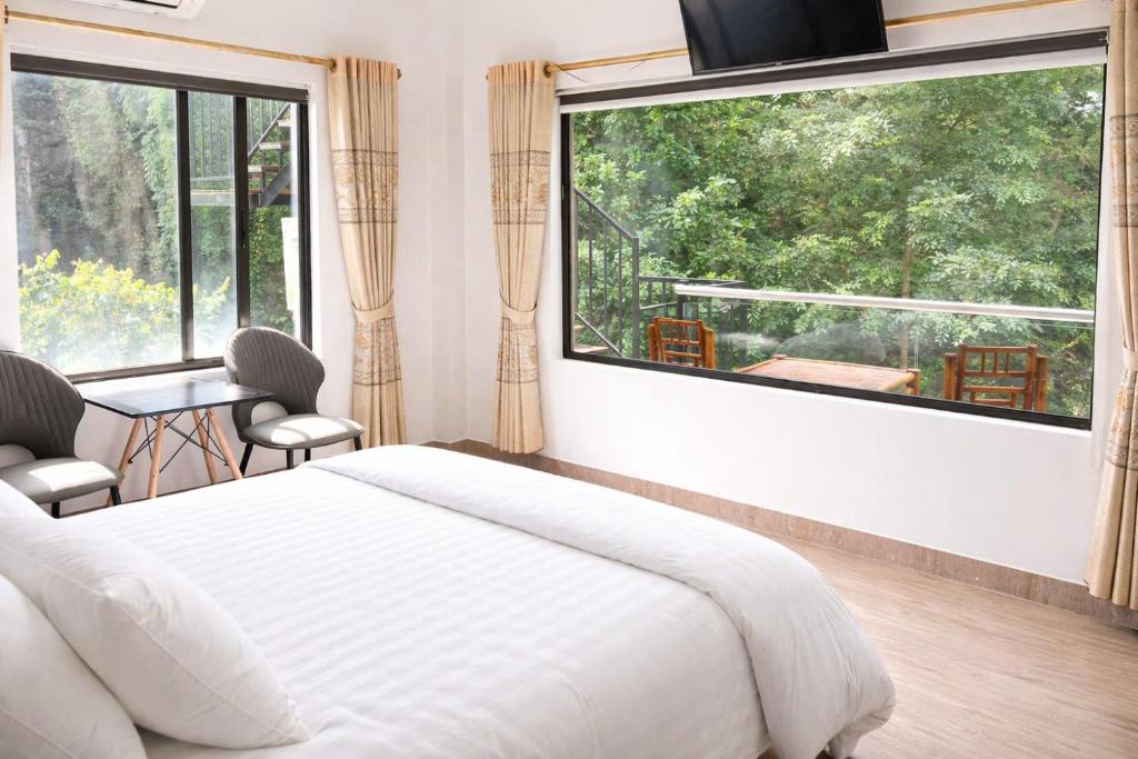 a bedroom with a bed and a large window at Thao Nguyen Homestay in Phong Nha