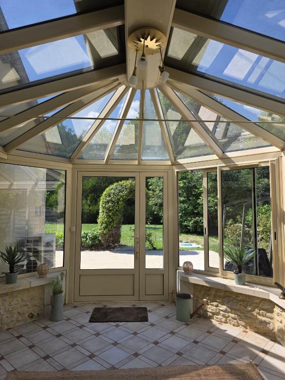 a conservatory with a glass roof with a window at domaine grangieras in Château-lʼÉvêque