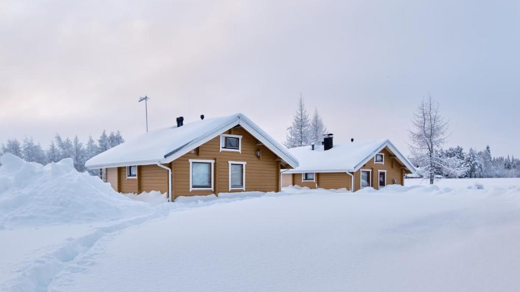 a log cabin in the snow with a driveway at Polar Tranquil Cabins in Kittilä