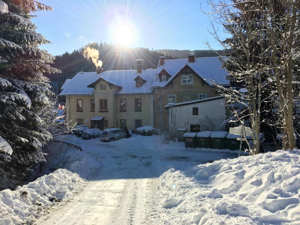 Una casa en la nieve con el sol detrás. en Haus Elena am Semmering en Steinhaus am Semmering
