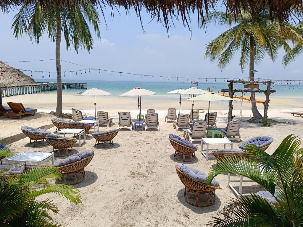 a beach with chairs and umbrellas and the ocean at Stay in Paradise Koh Rong in Koh Rong Island