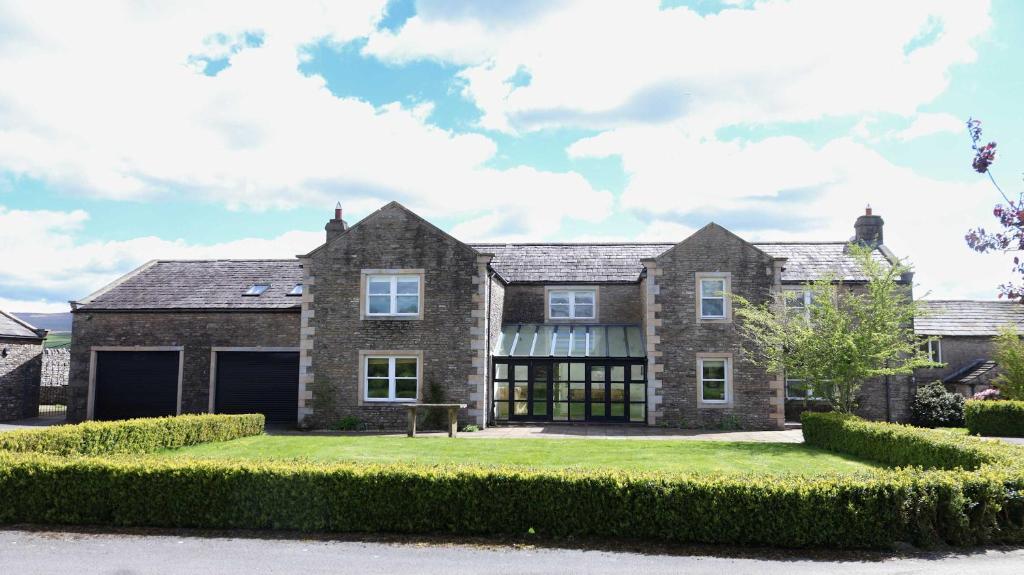 a large brick house with a large yard at Estatesmen Lodge, Hillside Farm in Kirkby Stephen