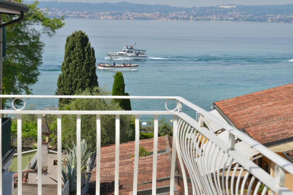 a balcony with a boat in the water at Hotel Luna in Sirmione