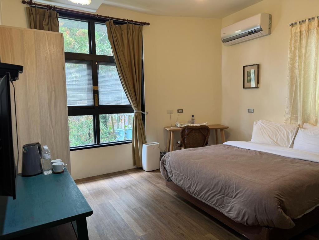 a bedroom with a bed and a large window at 泰森會館 in Lugu Lake