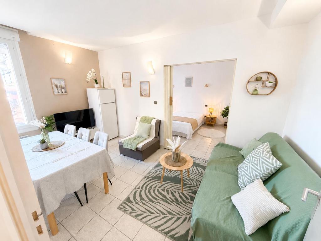 a living room with a green couch and a table at Résidence les 4 Horizons in Cerbère