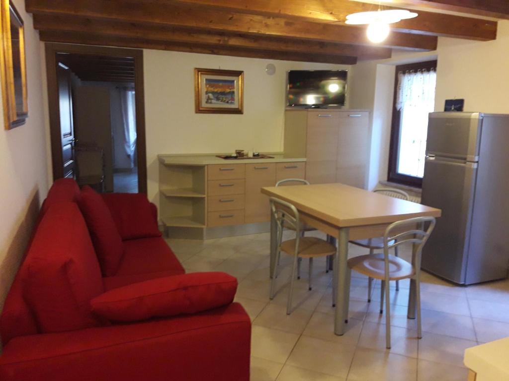 salon z czerwoną kanapą i stołem w obiekcie Appartamento" Le Bourg 61" VDA CIR 0208 w Aoście