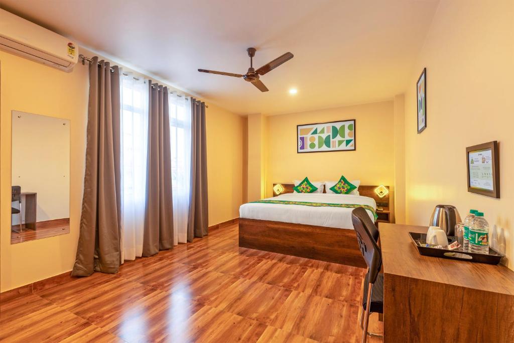 a bedroom with a bed and a desk in a room at Treebo Green Pearl Inn in Guwahati
