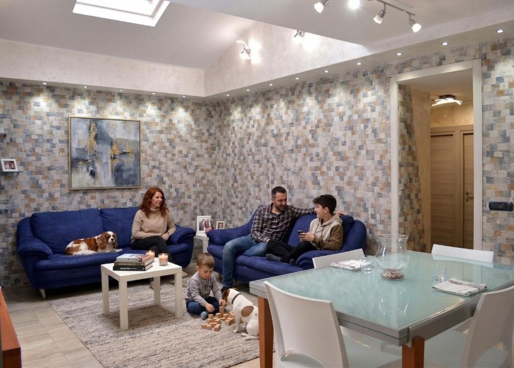 a family sitting on a blue couch in a living room at Meson Cavour in Avigliano