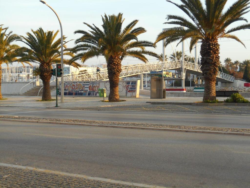 een straat met palmbomen en een brug op de achtergrond bij Vista da Marina in Lagos
