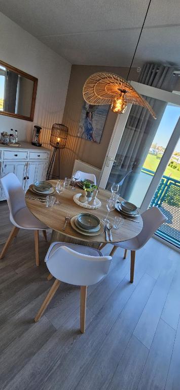 a wooden table with white chairs and a dining room at Bon Diaz at Sea in Julianadorp