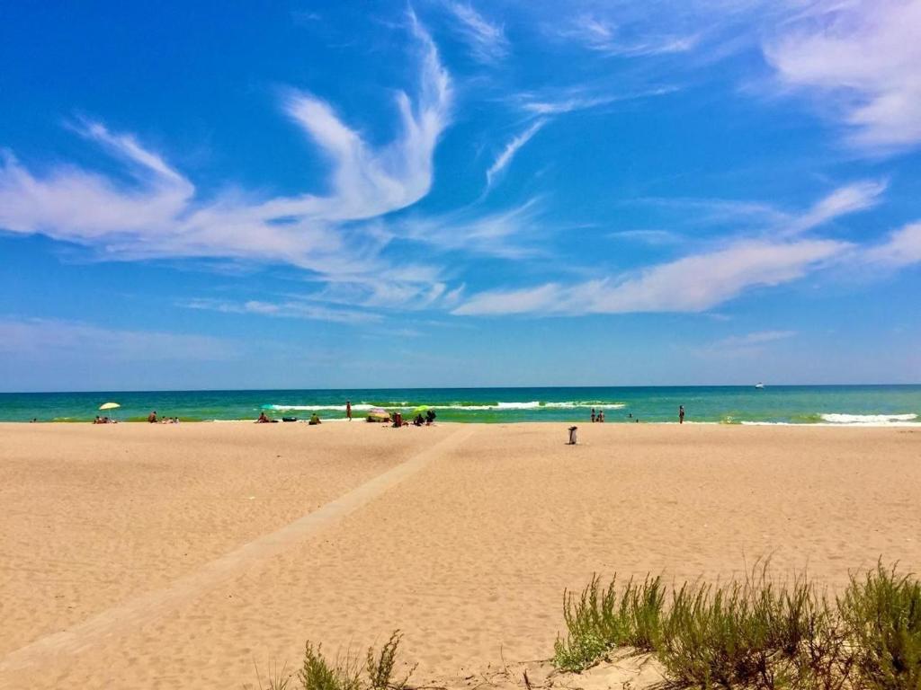 a beach with people and the ocean on a sunny day at Full relax in Zatoka