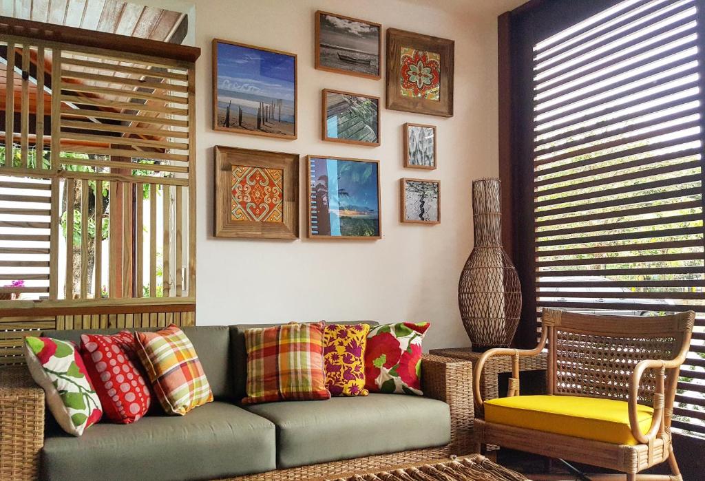 a living room with a couch and some pictures on the wall at Pousada Paraíso do Forte in Praia do Forte