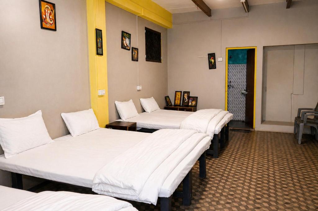 four beds lined up in a row in a room at Hotel Rudra Ganga View Near Temple in Varanasi
