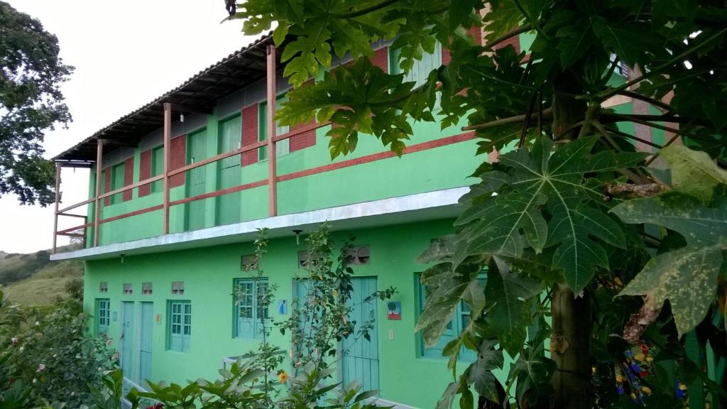 a green building with red and white stripes at Pousada Recanto Verde in Sao Benedito do Sul