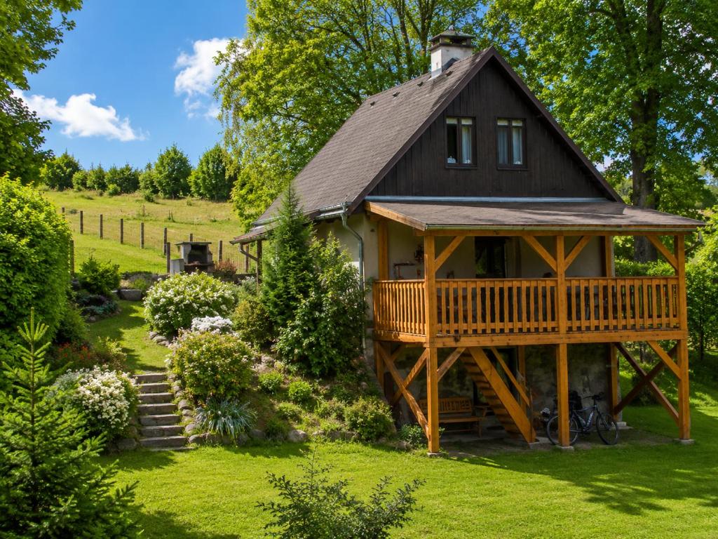 a cabin in the middle of a yard with a deck at Chata Růžová in Růžová