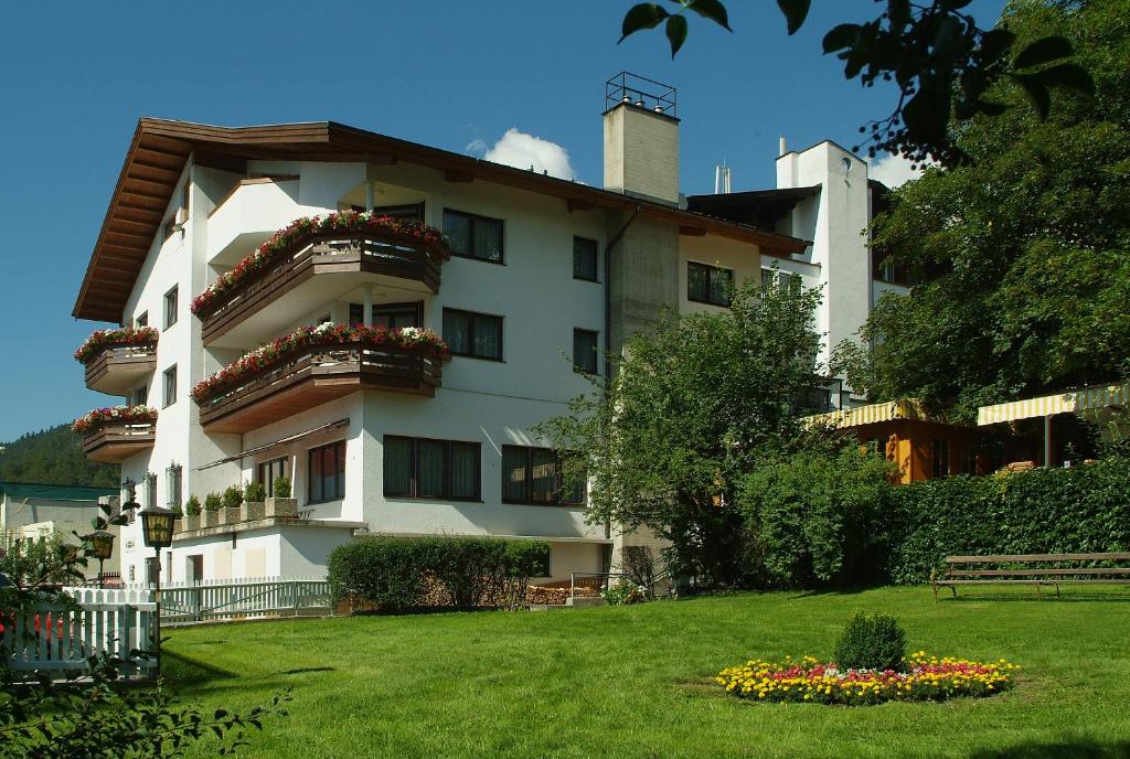 ein großes weißes Gebäude mit Blumen im Hof in der Unterkunft Appartement & Aparthotel Stern in Imst