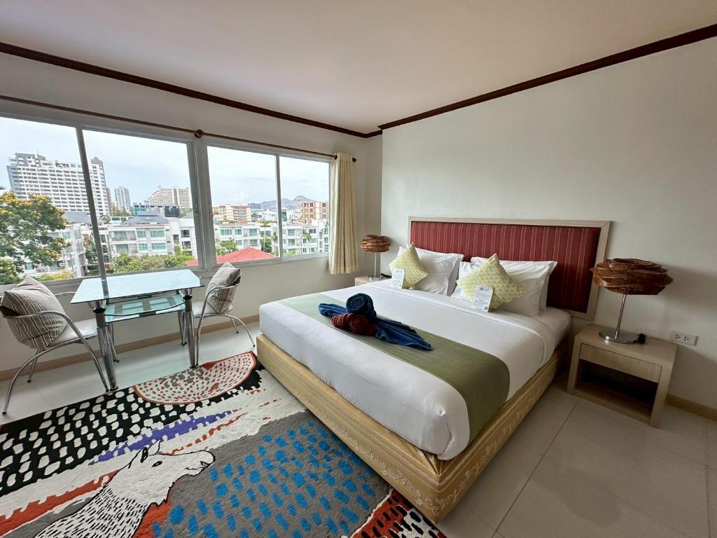 a bedroom with a large bed with a large window at Thipurai Beach Hotel in Hua Hin