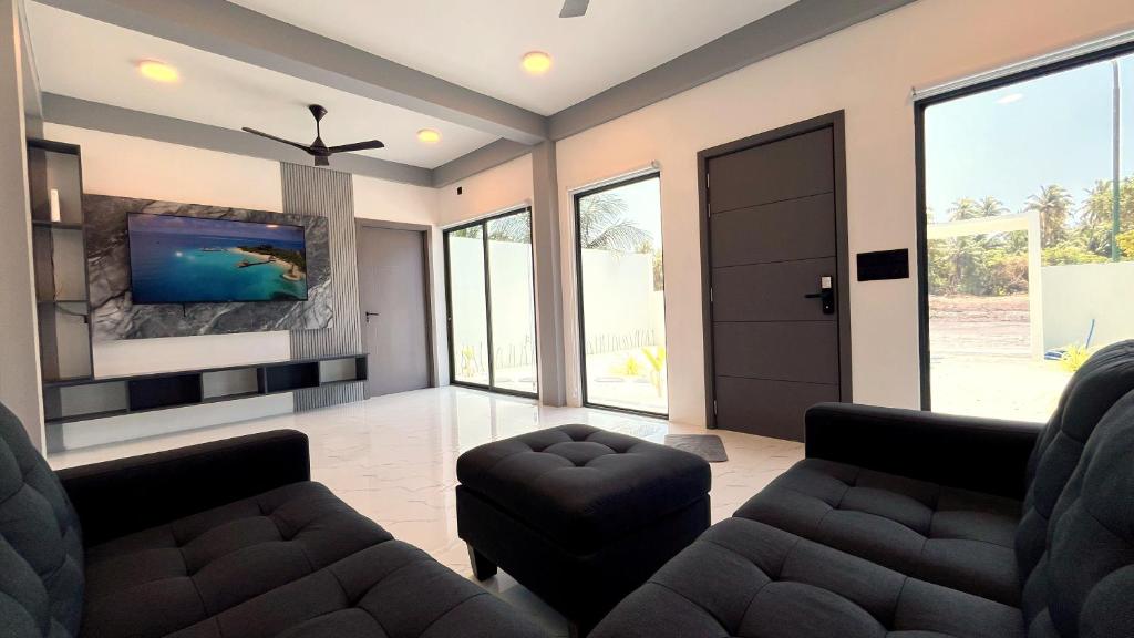 a living room with two couches and a flat screen tv at Ahiva Suites Goidhoo in Fehendhoo