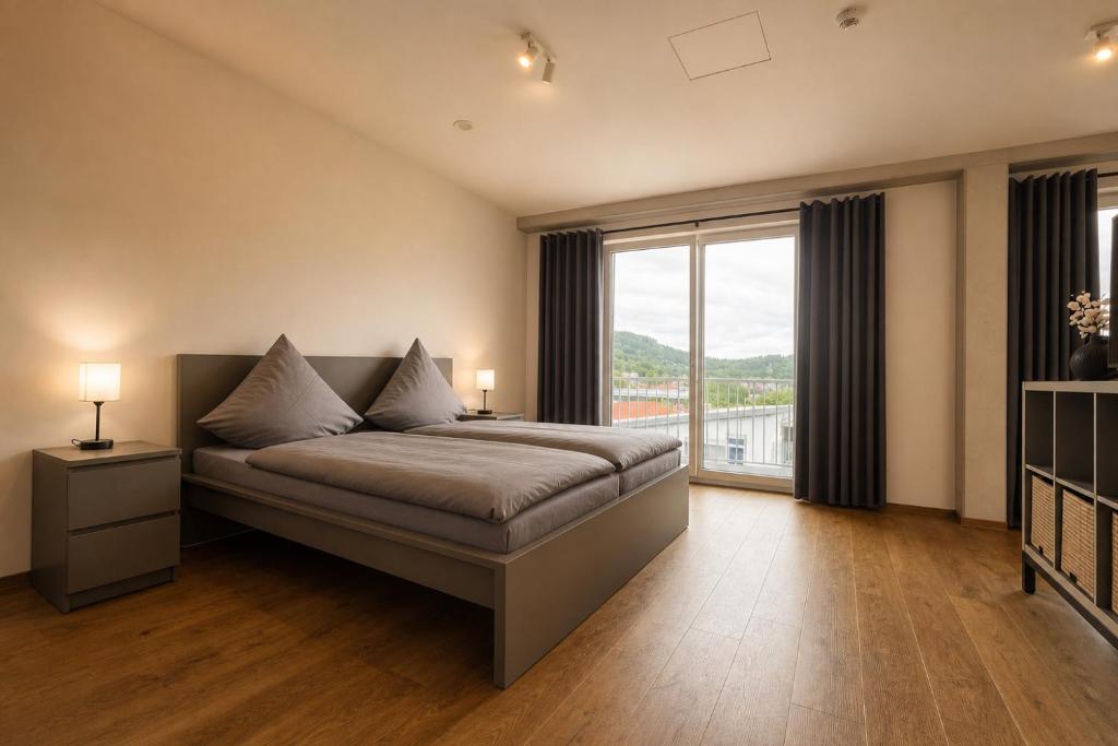 a bedroom with a bed and a large window at Planet Blue Smartments in Sulzbach an der Murr
