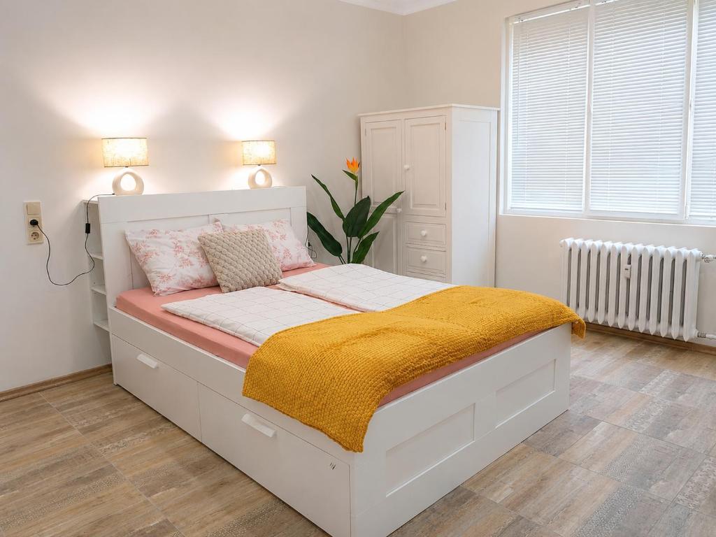 a bedroom with a white bed with a yellow blanket at NDK - Dream House in Sofia