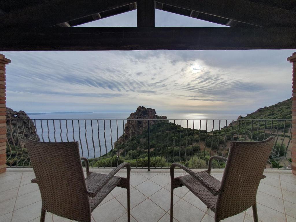 two chairs on a balcony with a view of a mountain at Villa Maris in Nebida