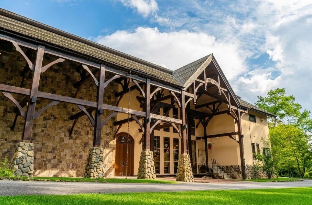 a large stone building with a gambrel roof at 山あいの静かなログハウス Quiet Mountain Log House with Indoor Hot Spring Bath in Gujo