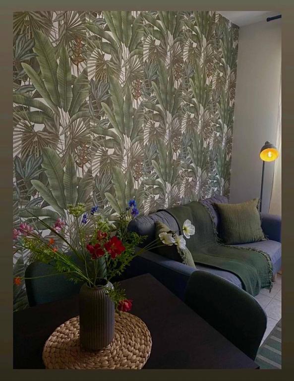 ein Wohnzimmer mit einer Couch und einem Tisch mit Blumen in der Unterkunft The Seven in Reggio nell'Emilia