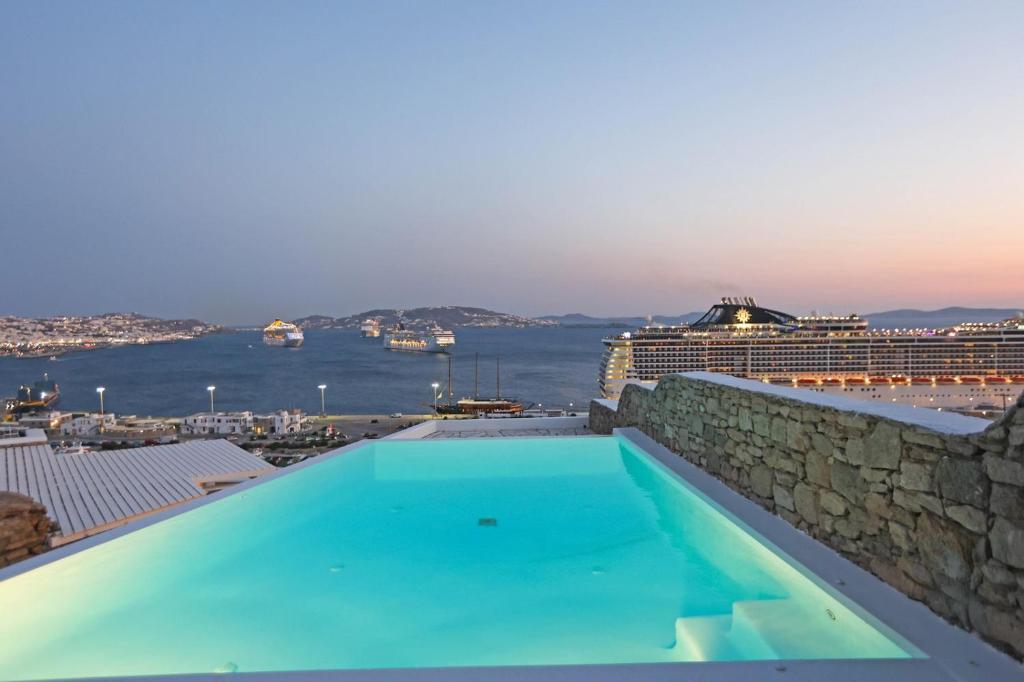 a swimming pool on top of a building with a cruise ship at Adikri Villas & Suites in Tourlos