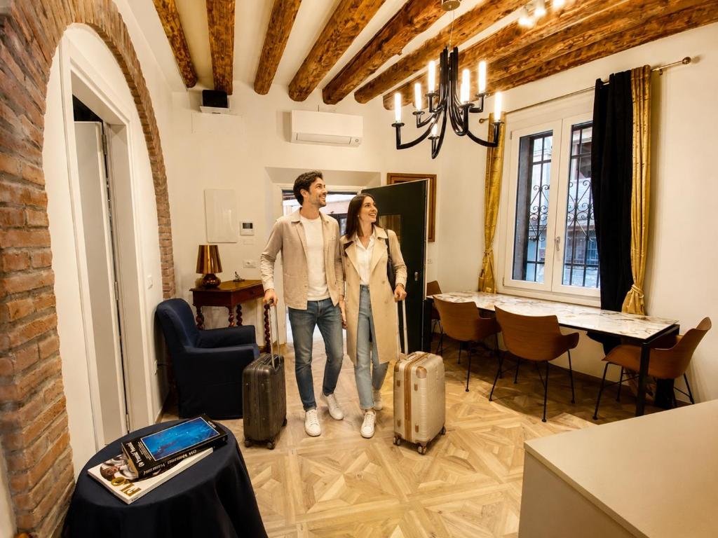 a man and woman standing in a room with suitcases at Guglie Garden in Venice