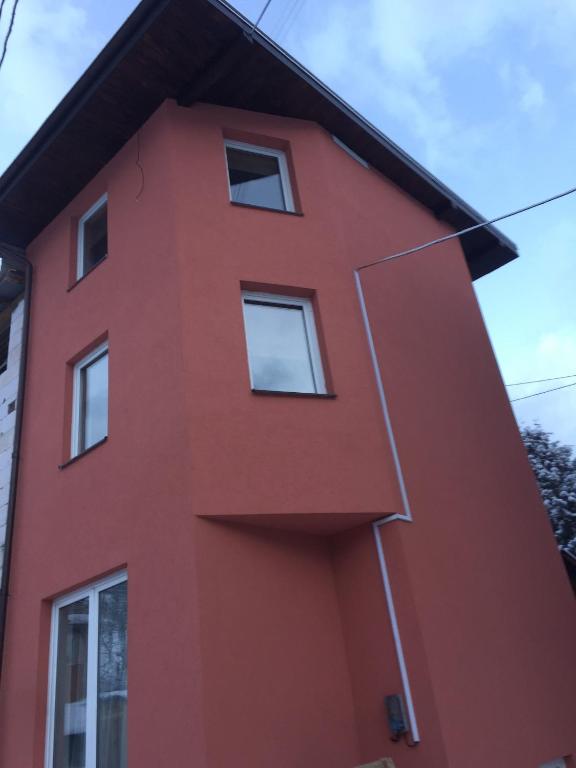 um edifício vermelho com janelas do lado em Mini-hotel Megora em Rakhiv