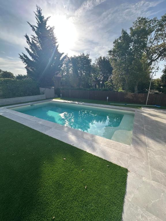 a swimming pool in the grass with the sun in the background at La jaima in Santa Ceclina