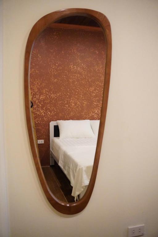 a mirror reflecting a bed in a room at Old Village House in Yên Bài