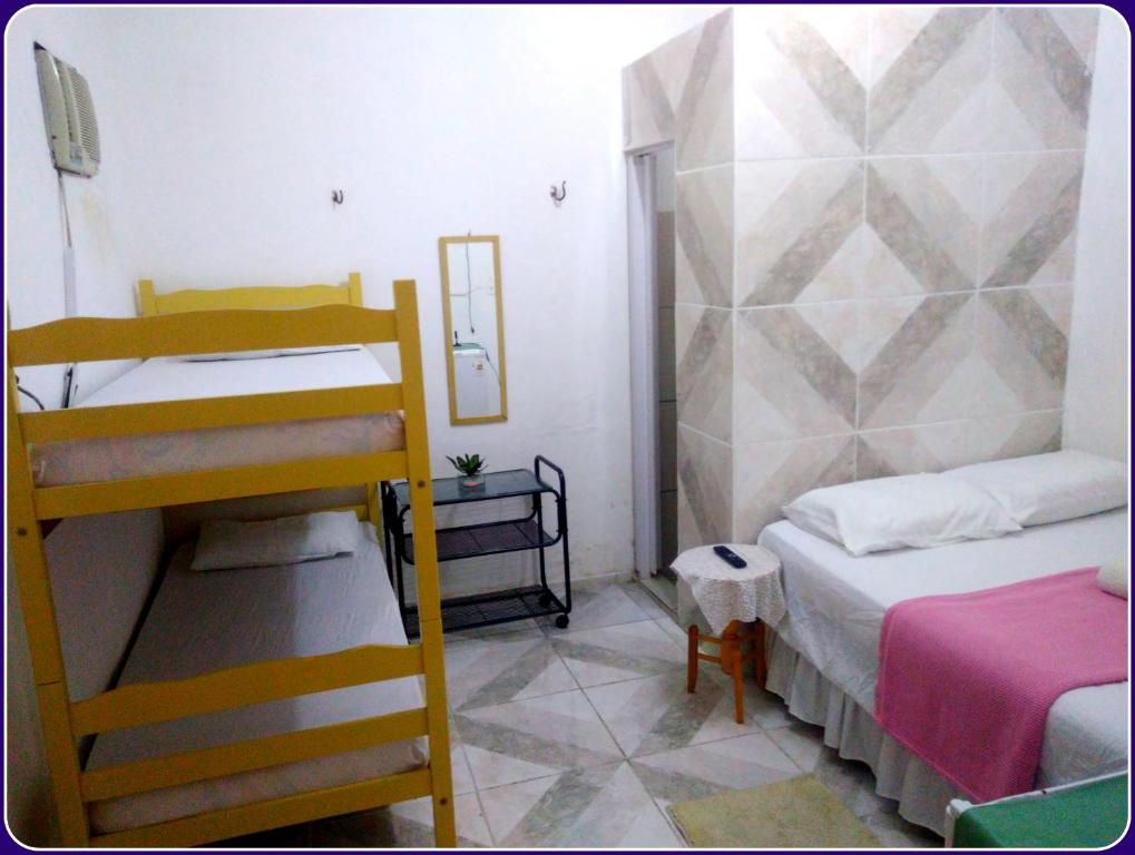 Habitación pequeña con 2 literas y manta rosa en Hospedaria Praia e Sol, en Fortaleza