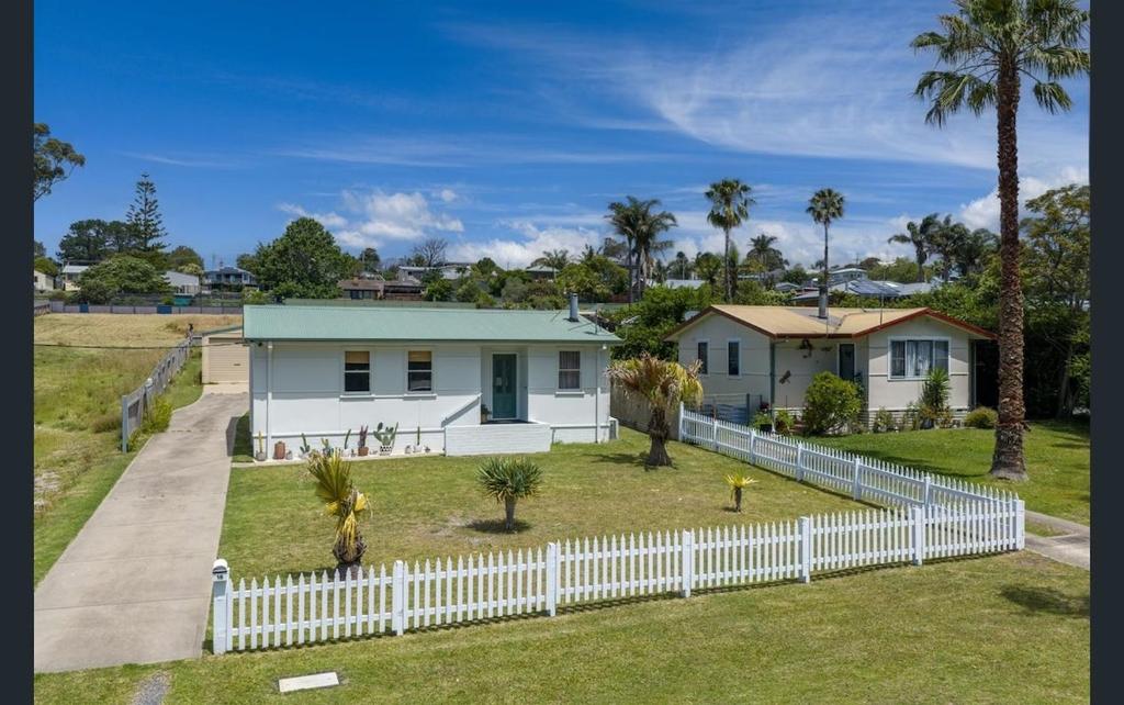 a white house with a white picket fence at Bungo Beach Shack in Eden