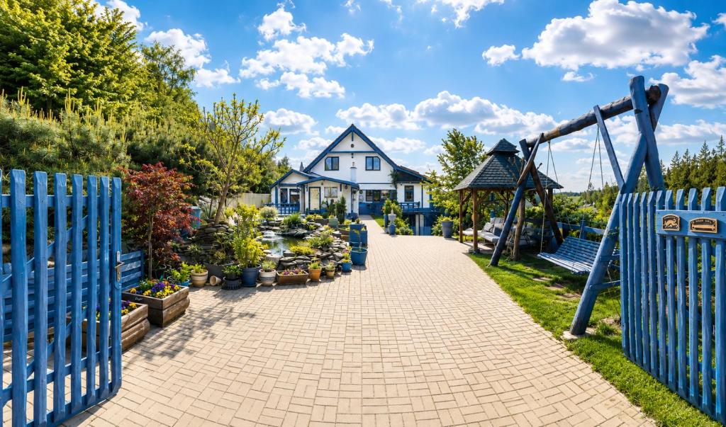 a playground in front of a house with a blue fence at Apartment Sunny Valley in Lhota u Lysic
