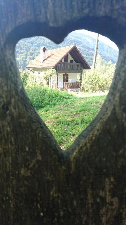 a view of a house through a heart shaped window at Hisa V Sadovnjaku in Logje