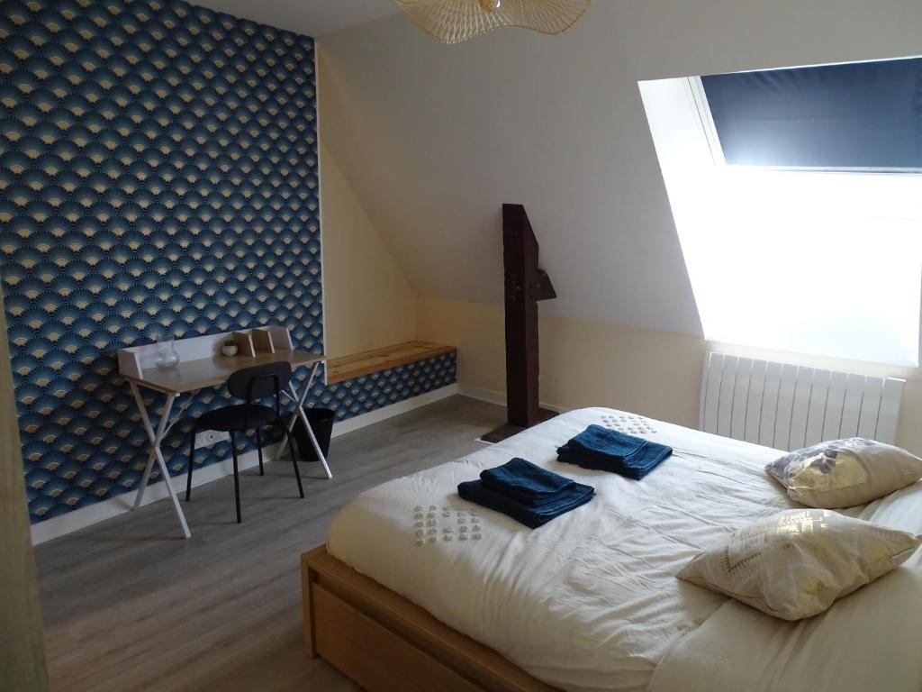 a bedroom with a bed with two blue towels on it at Bryce Canyon in Châteaubourg