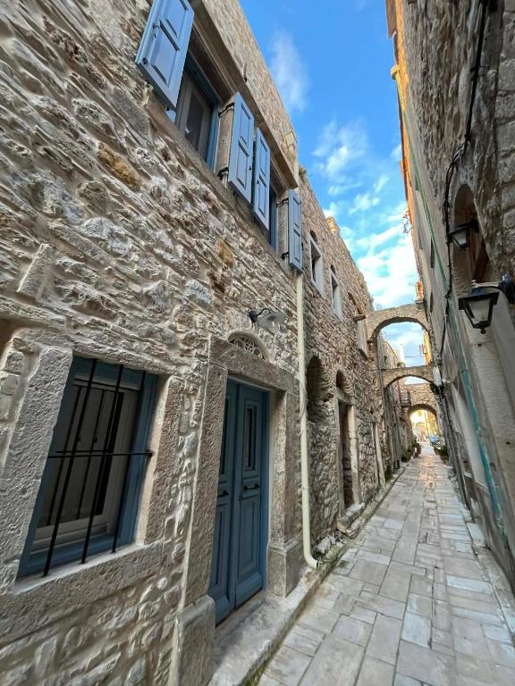 an alley in an old building with a blue door at Patossa in Chios
