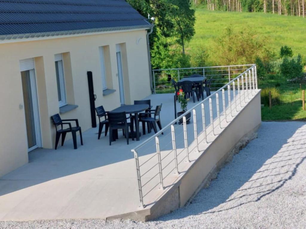 a balcony with tables and chairs on a house at L'Olivier in Les Mazures