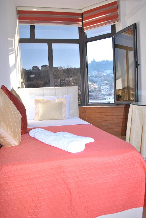 um quarto com uma cama grande e uma janela grande em Hotel The First em Gjirokastër