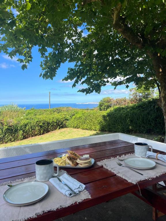 a picnic table with a plate of food on it at Termo Cottage in Lagoa