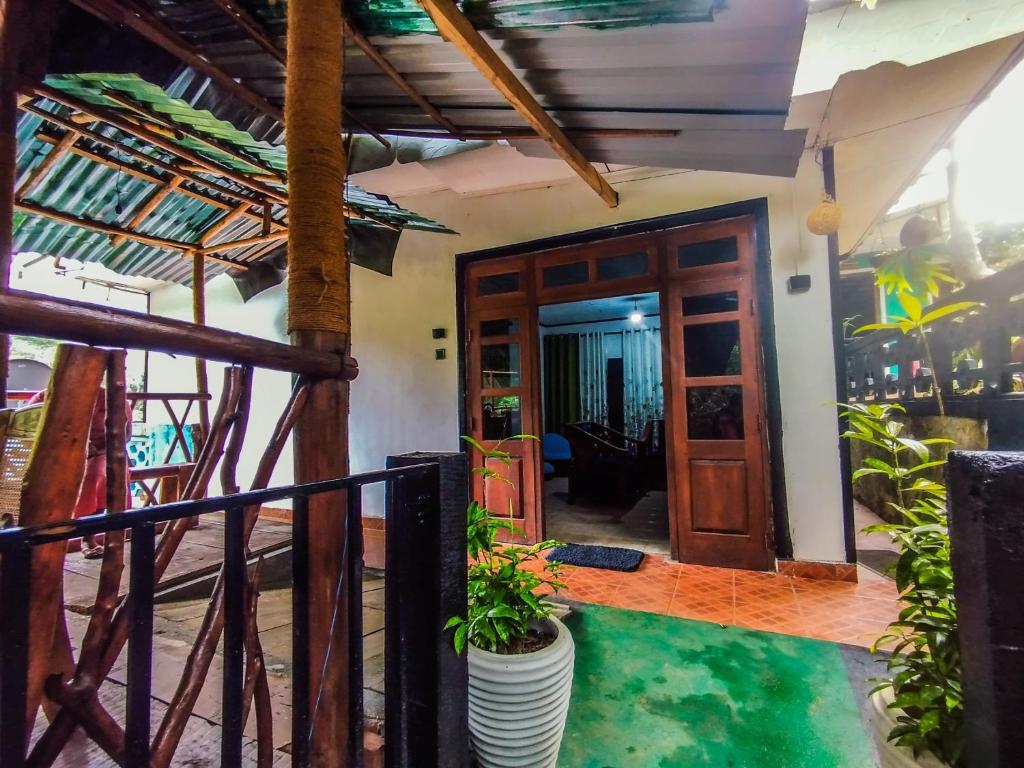 a room with a door and a balcony with plants at Friendship Villa-Ella in Nikawatawana